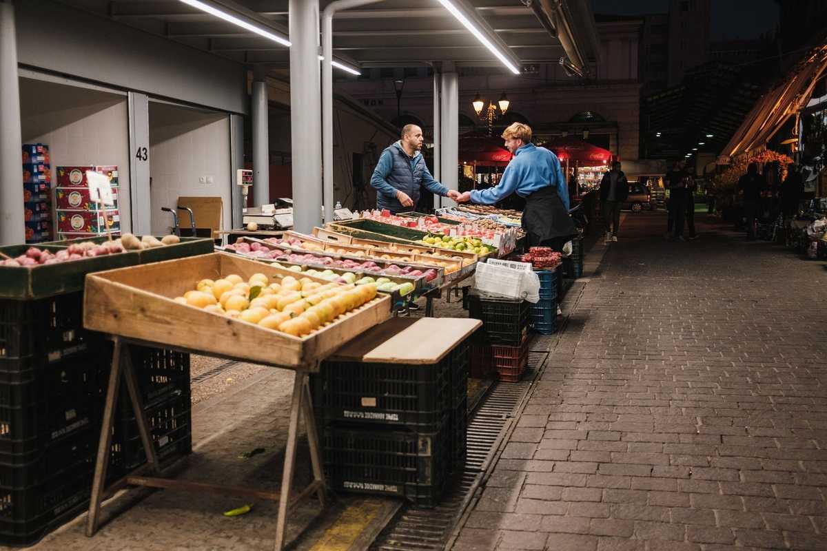 Marché de fruits en plein air la nuit, échanges entre clients et vendeurs Marché de fruits en plein air la nuit, échanges entre clients et vendeurs