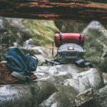 Sacs de couchage et chaussures sur rochers dans une forêt humide