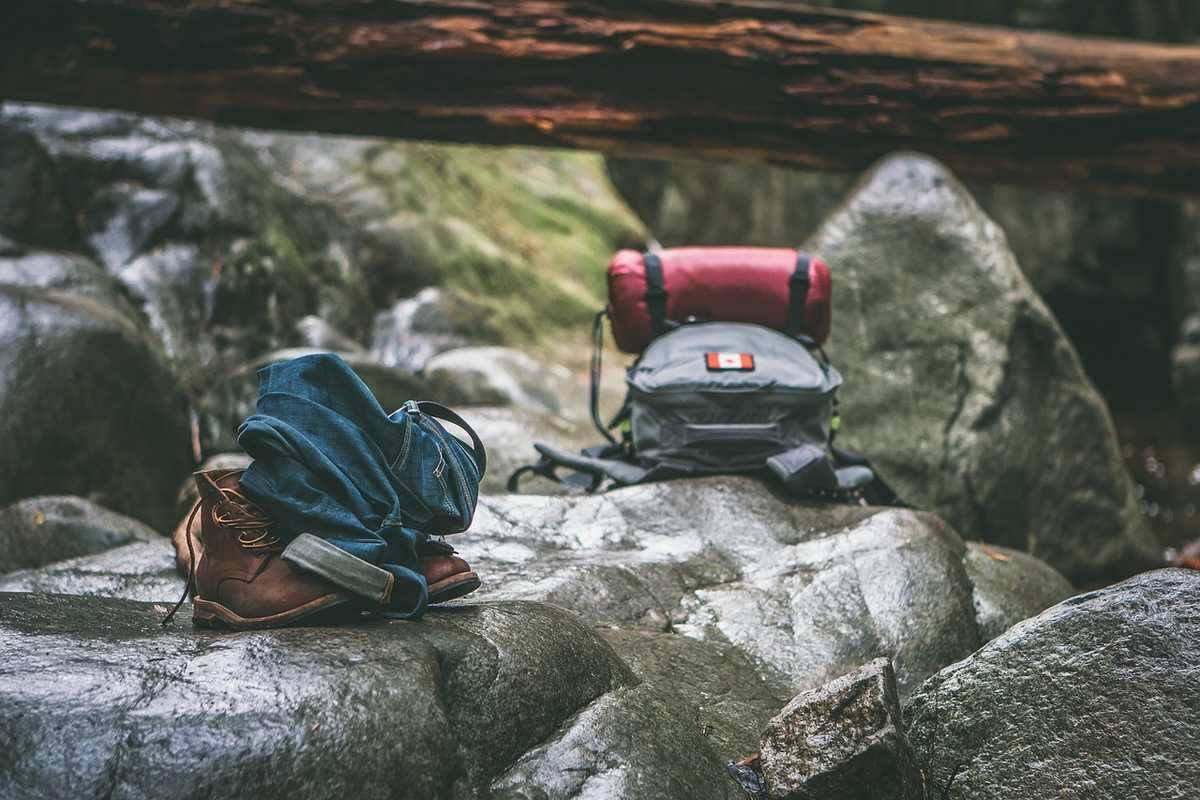 Sacs de couchage et chaussures sur rochers dans une forêt humide