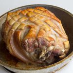 Un rôti de porc doré posé dans un plat en métal