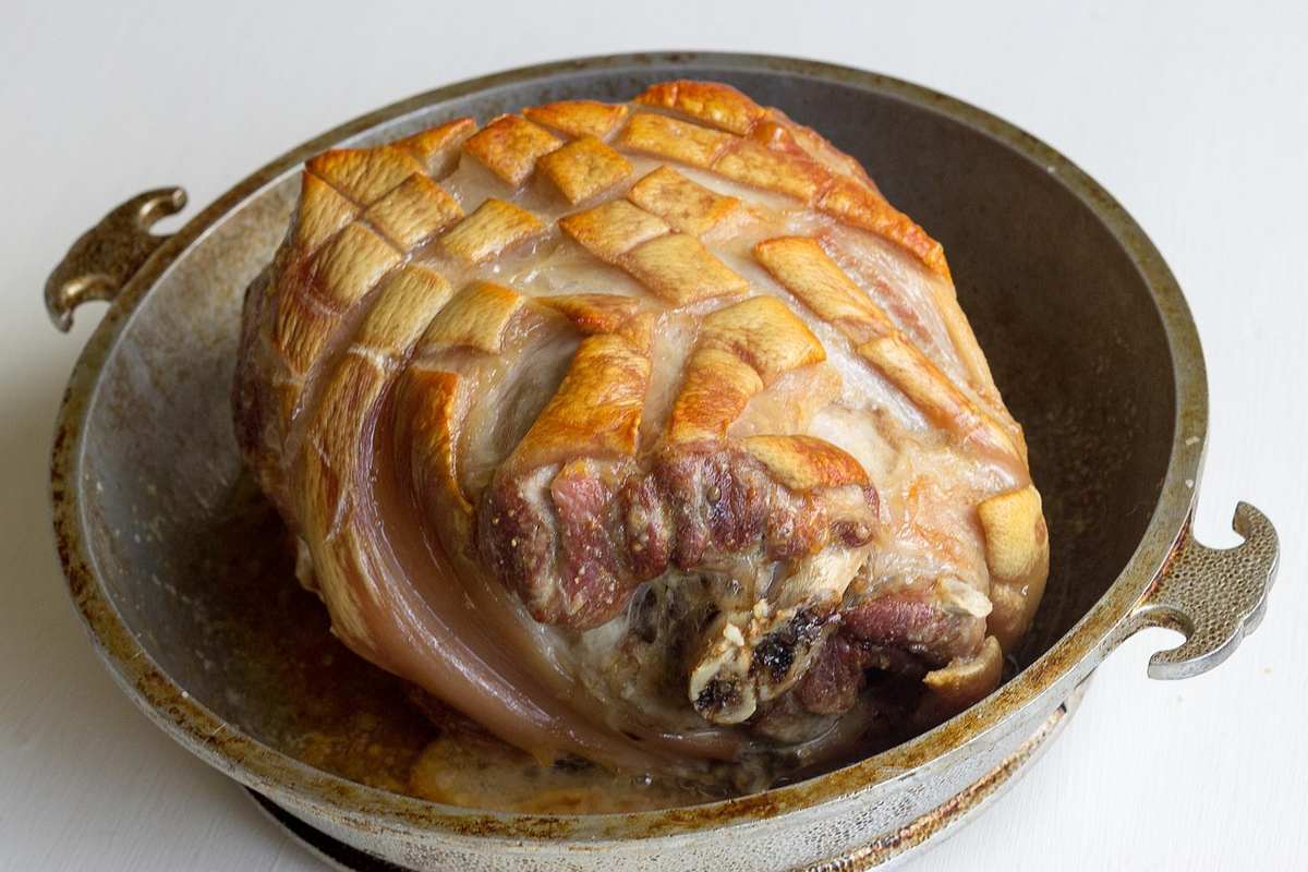 Un rôti de porc doré posé dans un plat en métal