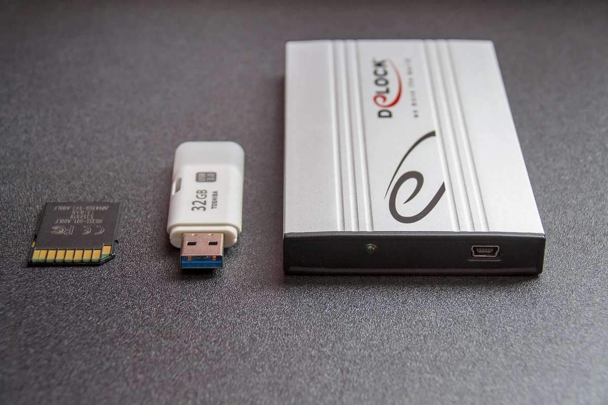 Carte SD, clé USB, et boîtier externe sur fond gris Carte SD, clé USB, et boîtier externe sur fond gris