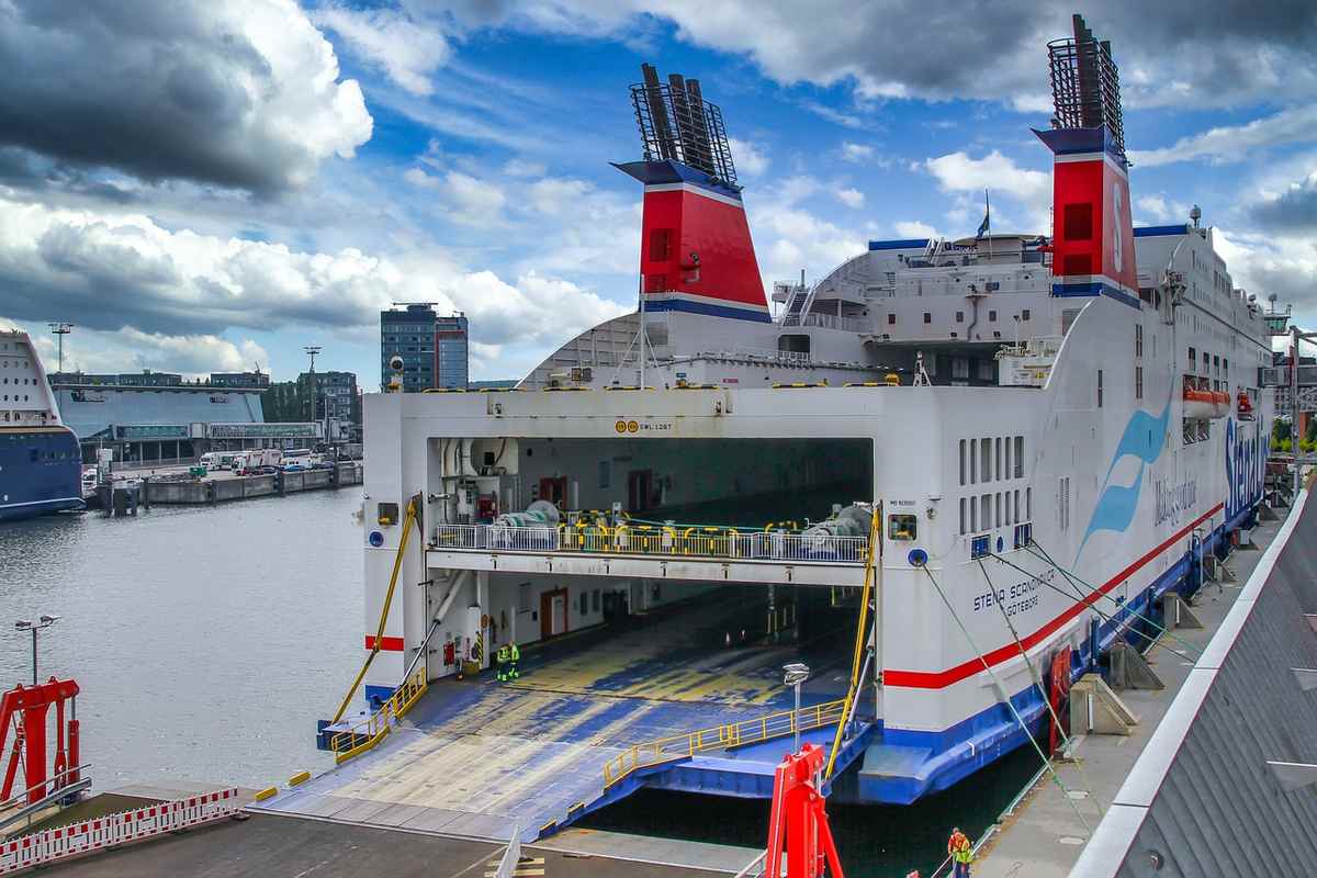 Un grand ferry blanc avec rampes ouvertes amarré au quai Un grand ferry blanc avec rampes ouvertes amarré au quai