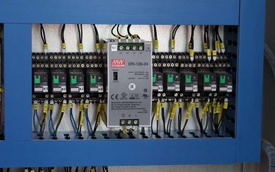 Un panneau électrique avec disjoncteurs, câbles et un régulateur
