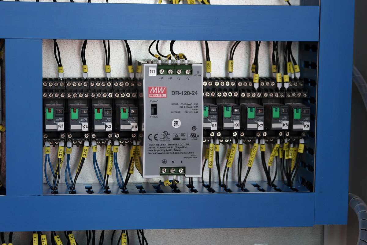 Un panneau électrique avec disjoncteurs, câbles et un régulateur